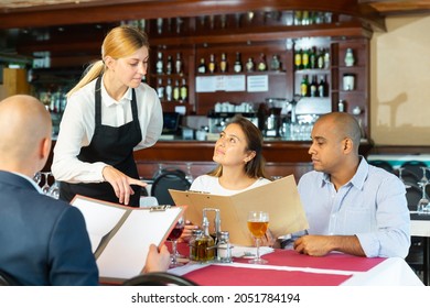 Polite Waitress Offers To Choose A Dish From The Menu