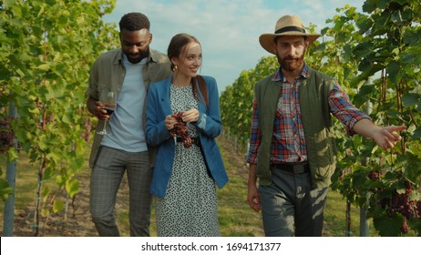 Polite winemaker welcoming guests at vineyard guiding excursion for romantic couple in grape valley of wine region. Honeymoon wine tour. - Powered by Shutterstock