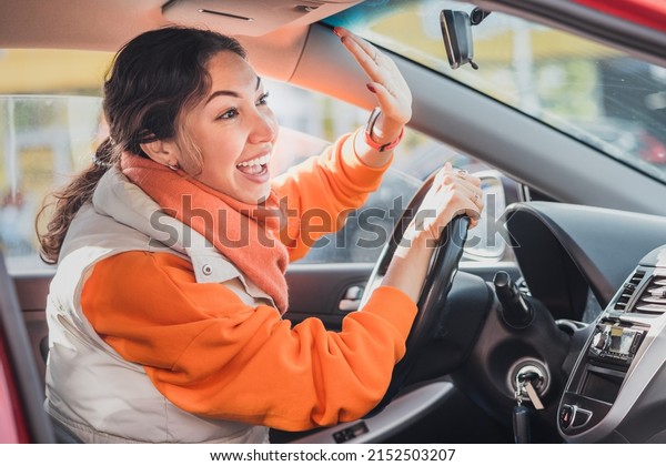 Polite woman driver raised her hand as a sign\
of respect and says thank you for giving way. Relations between\
people in traffic\
regulations