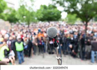 Political Protest. Demonstration. Microphone In Focus Against Blurred Crowd.