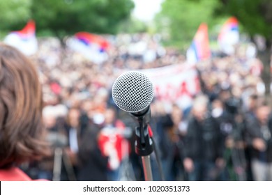 Political Protest. Demonstration. Microphone In Focus Against Blurred Crowd.