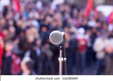 Political protest. Demonstration. Microphone in focus against blurred crowd. 