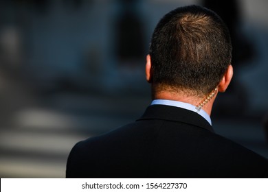 Politician Bodyguard Communicating Through An Earpiece.