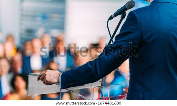 Politician during election campaign, speaking to\
the crowd from stage