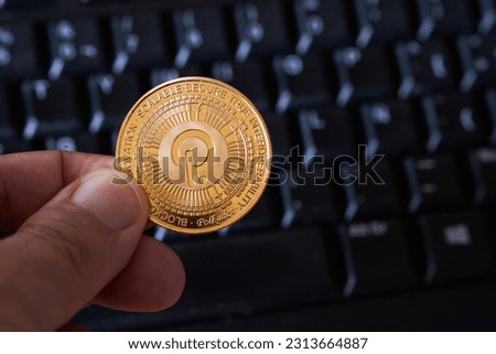 Polkadot cryptocurrency holding fingers and computer keyboard background