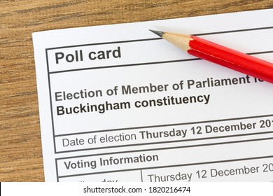 Poll card for a UK general election, voting information paper on desk with pencil