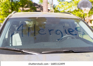Pollen on vehicle windshield with the word "Allergies" written in it.