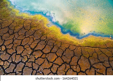 Polluted Water And Cracked Soil During Drought.