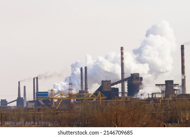 Polluting the air one cloud at a time. Shot of air pollution over an industrial area.