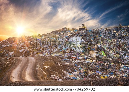 Pollution concept. Garbage pile in trash dump or landfill at sunset.