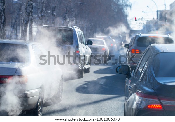 pollution from the exhaust of cars\
in the city in the winter. Smoke from cars on a cold winter\
day