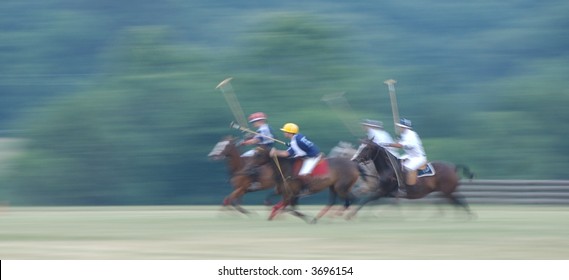 Polo Match at full gallop with intentional panning blur to emphasize speed