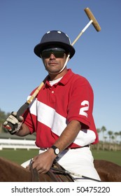 Polo Player holding polo stick on horseback on polo field