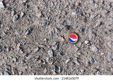 Poltava, Ukraine - April 14, 2022: Old cap of Pepsi cola on pavement, cold drink concept 