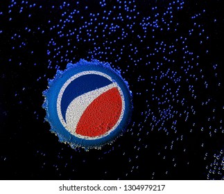 POLTAVA, UKRAINE - January 30, 2019: Pepsi cola cap in bubbles on a dark background. Pepsi is a carbonated soft drink that is produced and manufactured by PepsiCo.