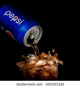 POLTAVA, UKRAINE - MARCH 22, 2018: Splash Pepsi Into A Glass On A Black Background. Pepsi Is A Carbonated Soft Drink Produced PepsiCo. Created In 1893