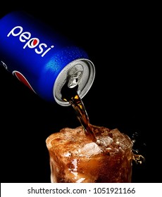 POLTAVA, UKRAINE - MARCH 22, 2018: Splash Pepsi Into A Glass On A Black Background. Pepsi Is A Carbonated Soft Drink Produced PepsiCo. Created In 1893