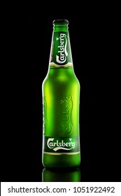 POLTAVA, UKRAINE - MARCH 22, 2018: Bottle Of Carlsberg beer on black  background. Danish brewing company founded in 1847.