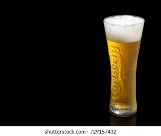 POLTAVA, UKRAINE - OCTOBER 6, 2017: Cold glass Of Carlsberg beer on black background. Danish brewing company founded in 1847.