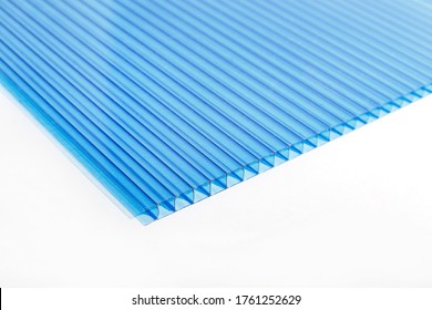 Polycarbonate plastic sheet panel image. PC hollow sheet for translucent roofing close up. Single light blue color sheet on white background