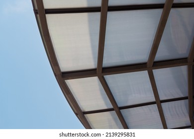 Polycarbonate Roofing used for house decoration, car park lot or outdoor walkway path, transparent roof with brown steel structure.