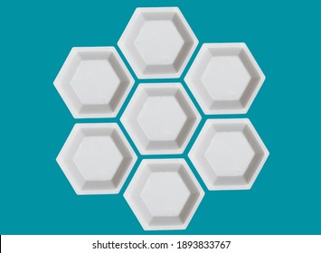 Polygon Of Hexagons. White Plastic Hexagonal Weighing Trays On Aegean Teal Background. Optical Illusion.                             