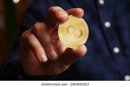 Polygon Matic cryptocurrency symbol golden coin in hand abstract concept.