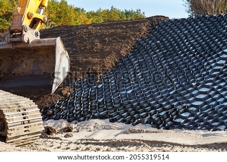 Polymer geogrid for filled with soil. Protection of sandy slopes with a geogrid