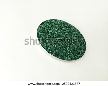 polymer granules. lucent green masterbatch cold cut type in laboratory pantry dish. isolated on white background. for industrial plastic product catalog design.