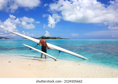 Polynesian Man Carrying His Outrigger Canoe In Bora Bora