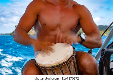 Polynesian Man Playing Drum On Boat In French Polynesia