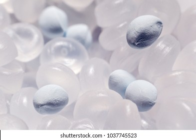 Polypropylene granule with a polymer additive close-up, background texture.