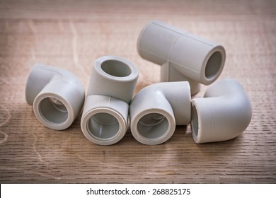 Polypropylene Pipe Fittings On Wooden Board 