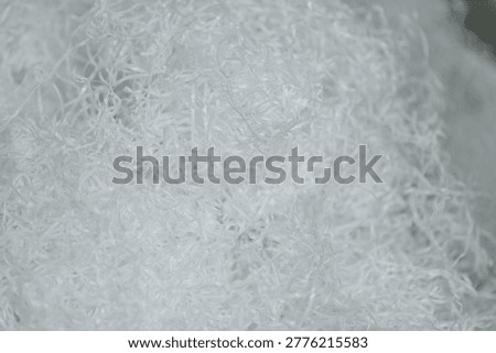 Polypropylene yarn creating a tangled pile of white synthetic fibers, illustrating industrial textile manufacturing process