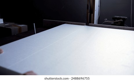 Polystyrene foam is cut using a hot wire. Cutting foam plastic for packaging goods. A white sheet of foam plastic is cut with a hot wire. - Powered by Shutterstock