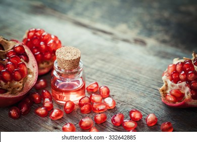 Pomegranate oil in bottle and garnet fruit with seeds on table. Selective focus. - Powered by Shutterstock