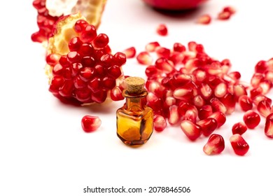 Pomegranate Oil With Scattered Pomegranate Seeds Isolated On White Background. Red Punica Granatum Essential Oil, Tincture, Extract, Infusion, Volatile Oils, Essence