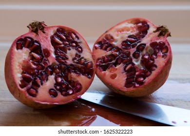 Pomegranate On A Wooden Cutting Board. A Fruit Full Of Nutrients, Vitamins And Antioxidants. It Is Also Believed To Be Anti Inflammatory, Reducing Blood Pressure And Different Types Of Cancers. 