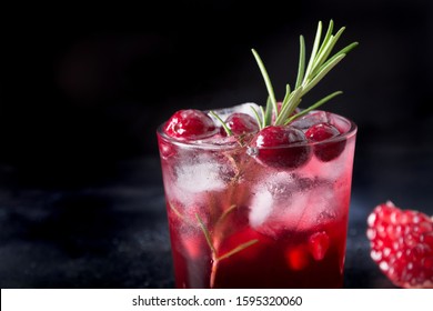 Pomegranate Rosemary Holiday Christmas Cocktail With Sparkling Wine, Cranberry, Club Soda On Black Table. Close Up.