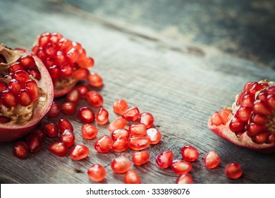 Pomegranate Slices And Garnet Fruit Seeds On Table. Selective Focus.