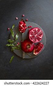 Pomegranate With Spoon On Black Textured Background. Overhead View Image.