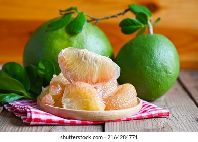 pomelo fruit on wooden background, fresh green pomelo peeled on plate and green leaf frome pomelo tree , pummelo , grapefruit in summer tropical fruit  in thailand 