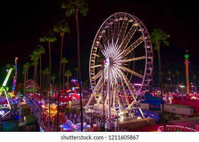 Pomona, California USA - September 23rd, 2018. Beautiful Enormous Ferris Wheel In LA Country Fair Are Decorated By Warm White Light With Aerial View Of Festival In Night.