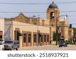 Ponca City, Oklahoma, USA - June 24, 2023: Morning sun shines on a church spire and the historic downtown cityscape of Ponca City.