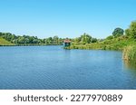 Pond or artificial lake formed by the construction of dam on small river. Beautiful rural landscape of Central Europe