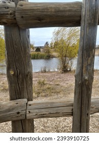 pond visible through wooden fence - Shutterstock ID 2393910725