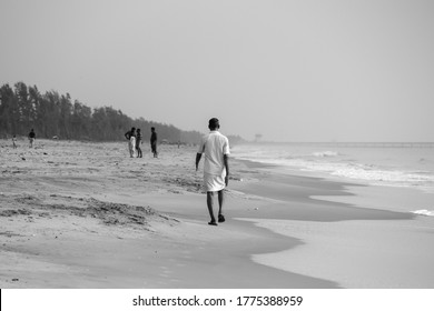 PONDICHERRY, INDIA - July 17: The Old Man Wearing Dhoti, Waking On The Sea Shore And Moving Forward Towards The Road 17, 2020 In Pondicherry, India.