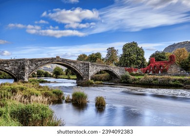 Pont Fawr, famous medieval stone bridge across the river Conwy, and court house covered in red ivy Llanrwst, Caernarfon, North Wales