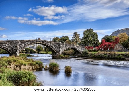 Pont Fawr, famous medieval stone bridge across the river Conwy, and court house covered in red ivy
 Llanrwst, Caernarfon, North Wales