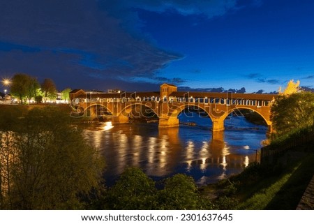 Ponte Coperto (covered bridge) over Ticino river in Pavia at blue hour, Lombardy, italy.